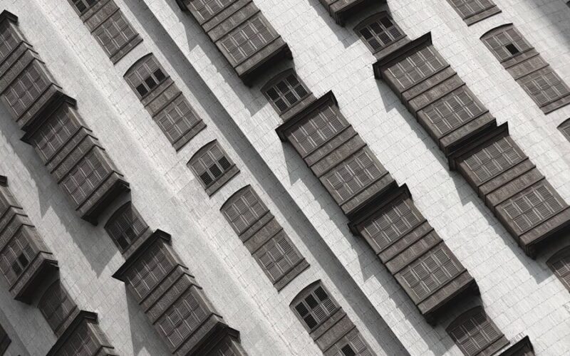 Rows of traditional wooden balconies on a white building.