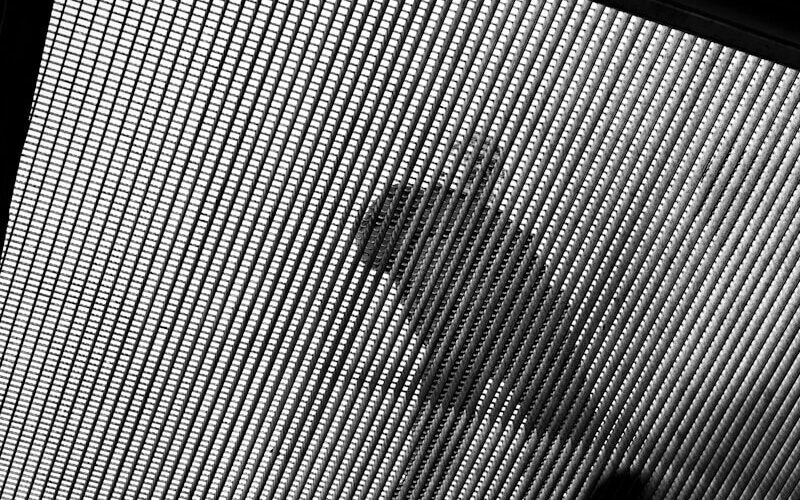 Abstract pattern of light and shadow on mesh